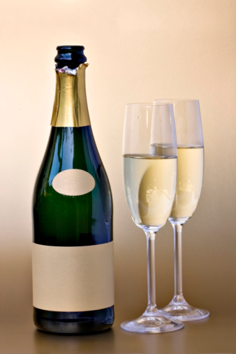 Bottle of champagne with gold blank label and two glasses