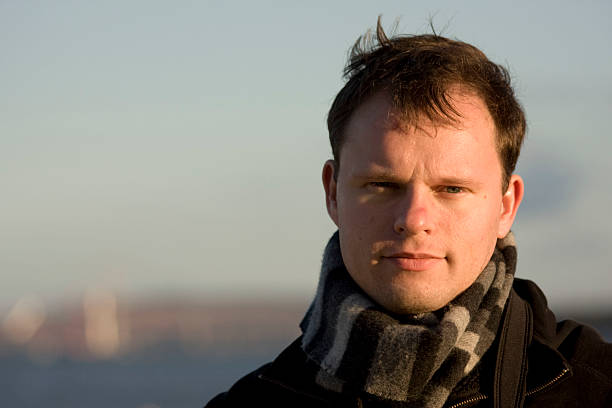 istock Man with a striped scarf around his neck squinting his eyes 92206807