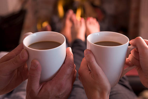 istock Feet warming at fireplace with hands holding coffee 92207486