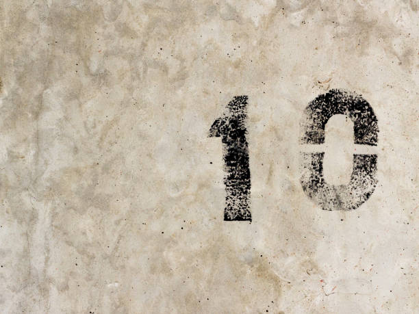 istock Number ten one zero 10 1 0 black painted on old rugged light grey concrete wall background 922077372