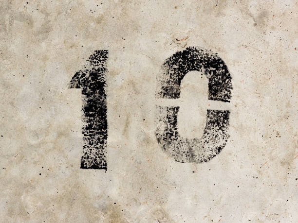 istock Number ten one zero 10 1 0 black painted on old rugged light grey concrete wall background 922077382
