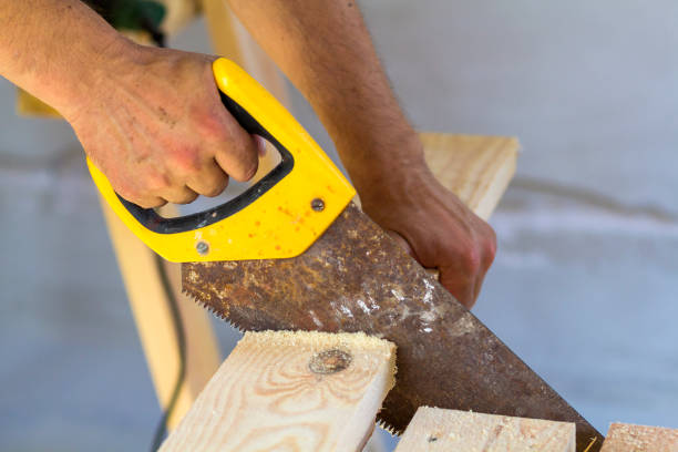 istock Carpenter hand with saw cutting wooden boards 922083898