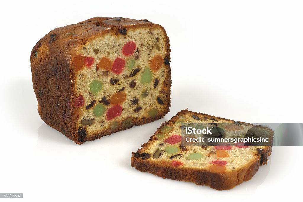 A Christmas fruit cake with one slice cut (XL) A freshly baked isolated loaf of candied Christmas fruitcake. Fruitcake Stock Photo