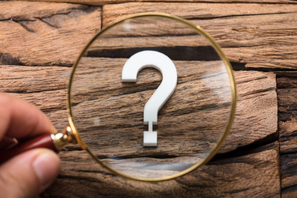 istock Hand Holding Magnifying Glass Over Question Mark On Wood 922088446
