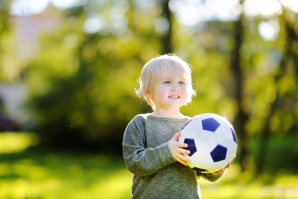 istock Little boy having fun playing a soccer game on sunny summer day 922088682