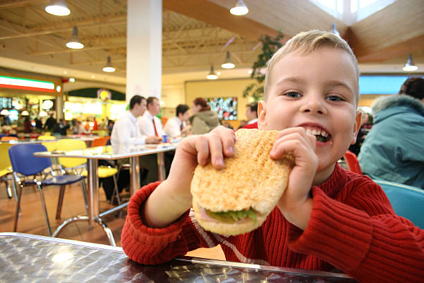 bambino mangiare hamburger - repast foto e immagini stock