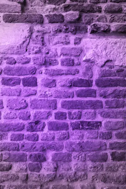 Photo of Ultra Violet Trendy color concept. Brick wall is painted on ultra violet color Pantone