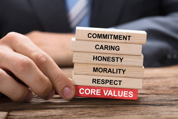 istock Businessman Holding Red Core Values Block Under Wooden Tower 922106830
