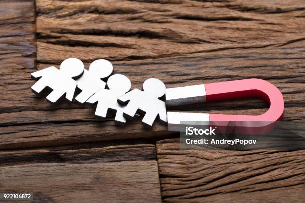 Magnet Attracting People On Wood Stock Photo - Download Image Now - Magnet, Recruitment, Love At First Sight