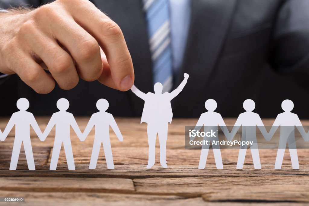 Businessman Holding Successful Paper Executive Amidst Teamchain Midsection of businessman holding successful paper executive amidst team on table Passion Stock Photo