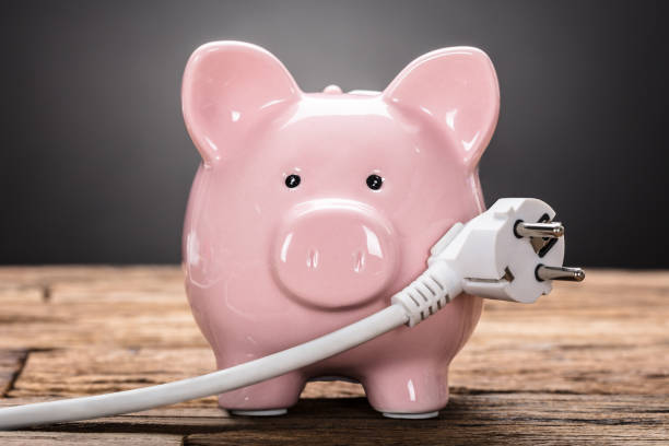 Piggybank With Plug On Wooden Table