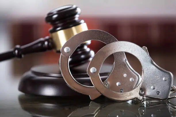 Close-up Of Handcuffs And Gavel In Courtroom