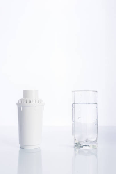 substituição de filtro de água e copo de água purificada em fundo branco, reflexão - pouring water carafe glass - fotografias e filmes do acervo