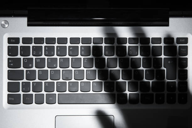istock Shadow Of Person's Hand Falling On Laptop Keypad 922112222