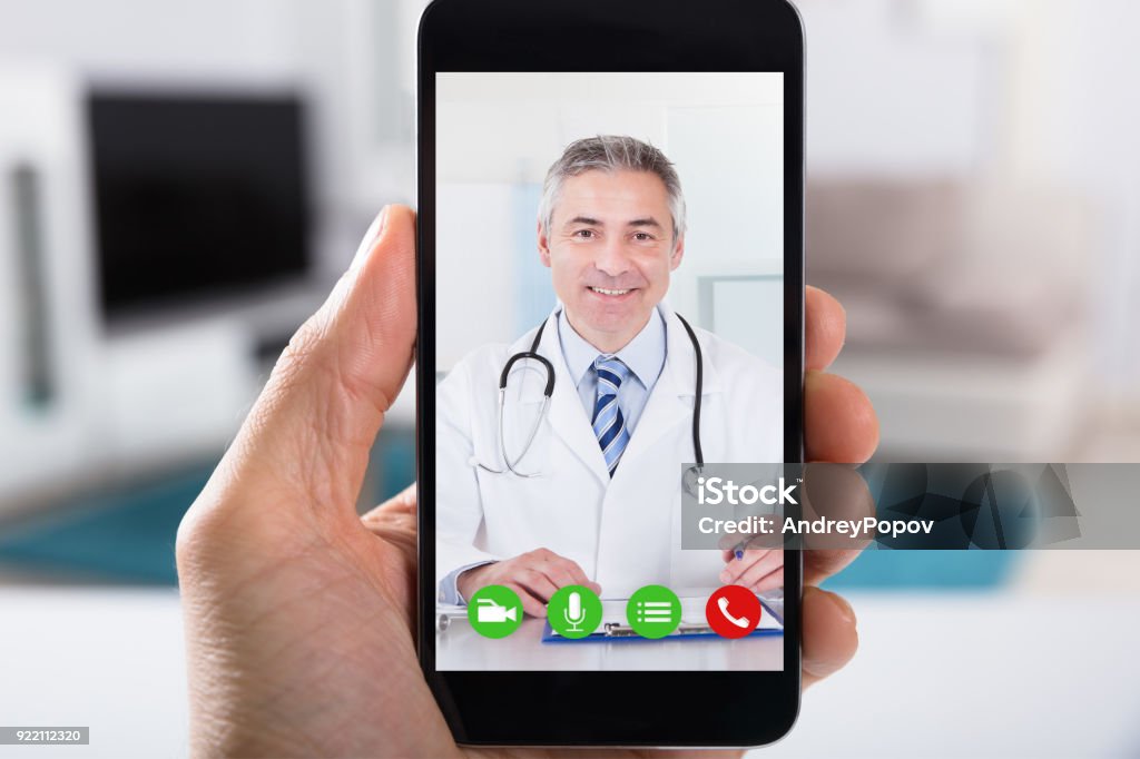 Persona videoconferencia con médico de Smartphone - Foto de stock de Doctor libre de derechos