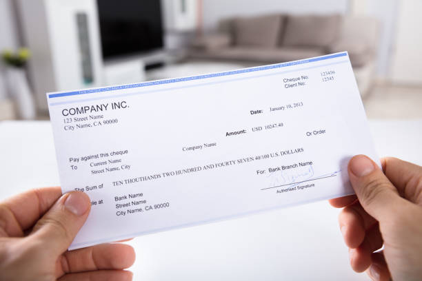 Person Holding Cheque Close-up Of A Person's Hand Holding Cheque bowie seamount stock pictures, royalty-free photos & images