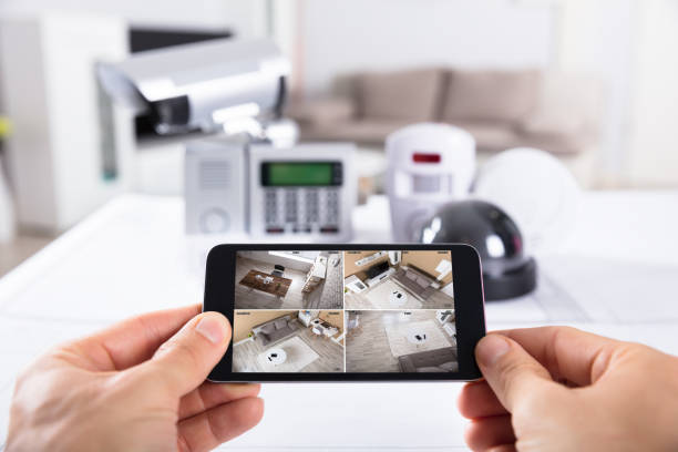 istock Person Holding Mobile Phone With CCTV Camera Footage On Screen 922112500