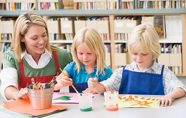istock Kindergarten teacher sitting with students in art class 92211506