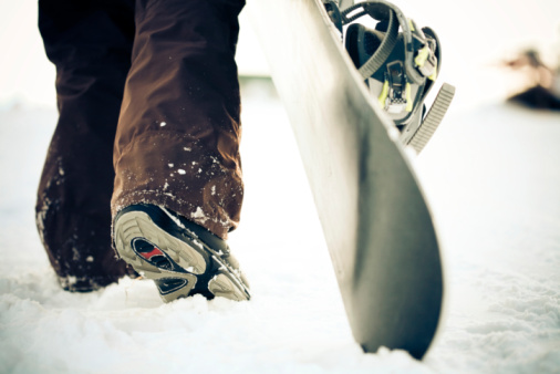 Snowboarder dragging the snowboard over the snow