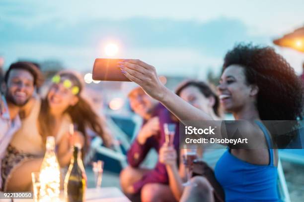 Happy Friends Taking Selfie With Smartphone At Beach Party Outdoor Young People Having Fun At Kiosk Bar Drinking Champagne Soft Focus On Mobile Cell Phone Youth Lifestyle And Vacation Concept Stock Photo - Download Image Now