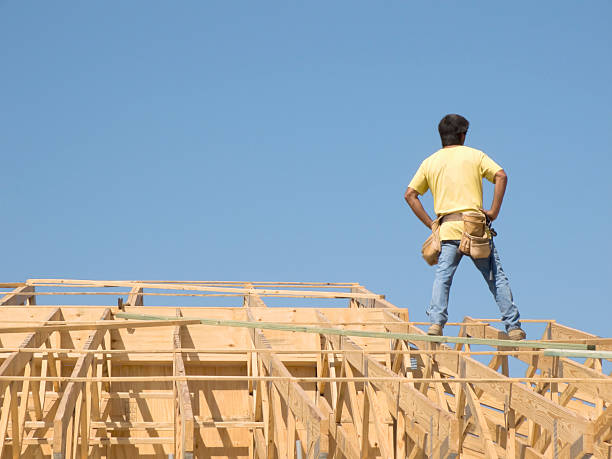 Carpenter on roof trusses stock photo