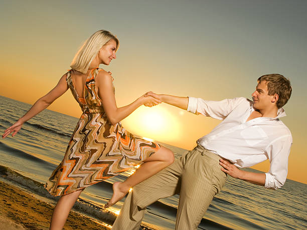 istock Young couple dancing near the ocean at sunset 92214049