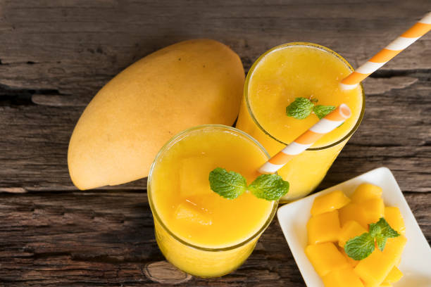 mango smoothies juice mango smoothies juice and ripe mango fruits. Yellow fruit on old wooden floor, drink in the morning to good health. MANGO stock pictures, royalty-free photos & images