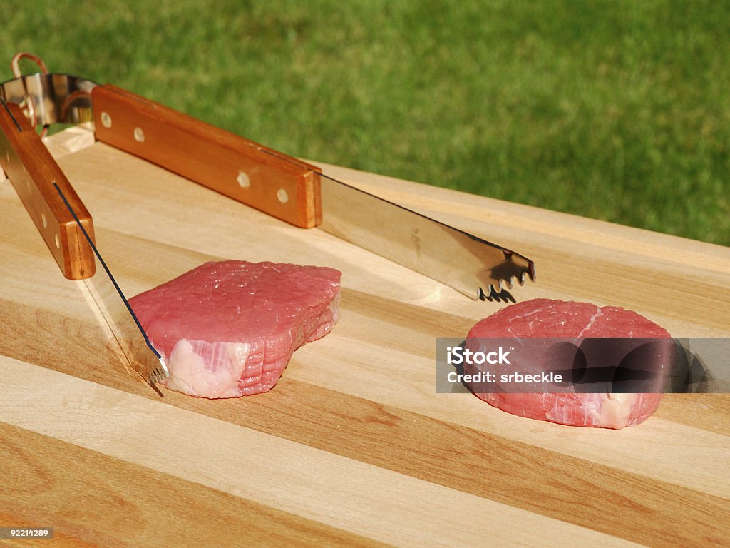 Raw steak with tongs  Beef Stock Photo