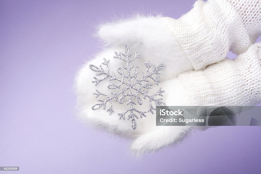 Mani in guanti bianchi tenendo inverno con fiocchi di neve - Foto stock royalty-free di Abbigliamento