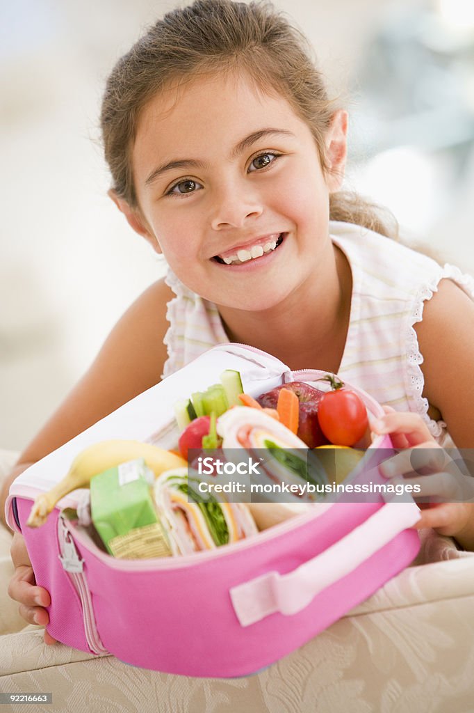 Молодая девушка держит Завтрак в пакете - Стоковые фото Школьный обед роялти-фри