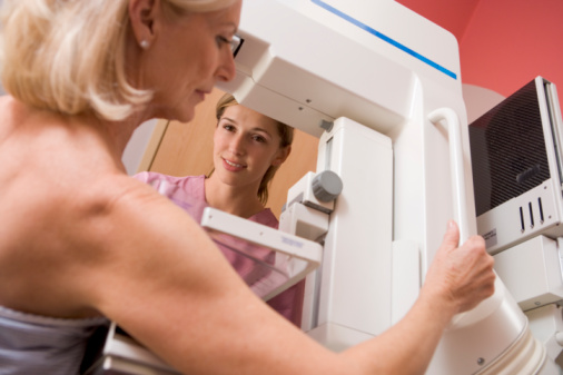 Nurse Assisting Patient Undergoing Mammogram in hospital