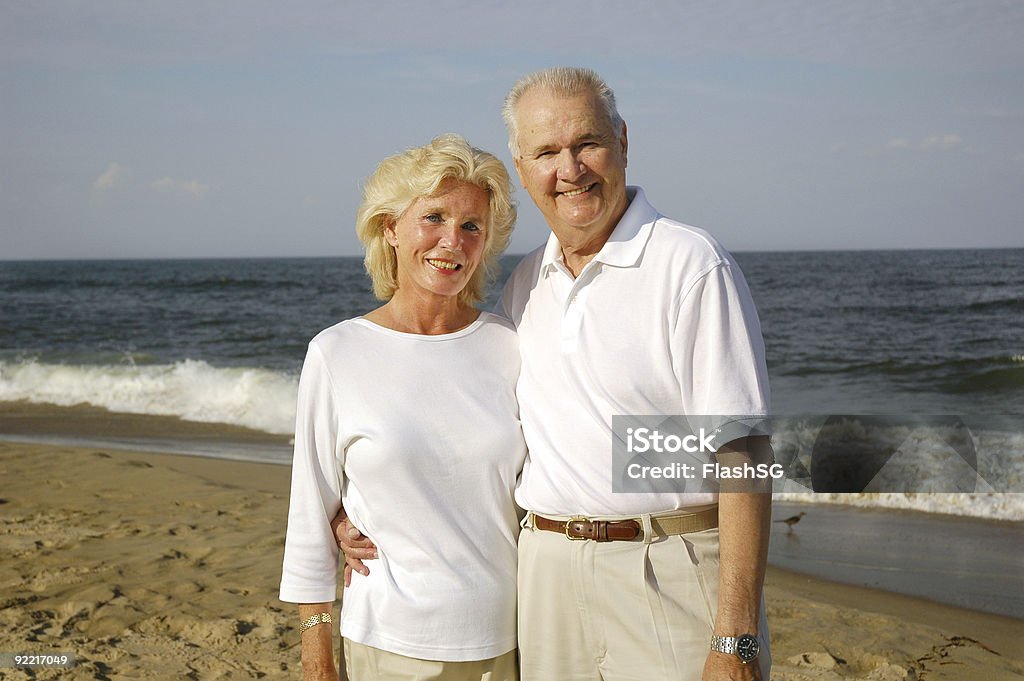 Couple Senior souriant sur la plage - Photo de 50ème anniversaire libre de droits