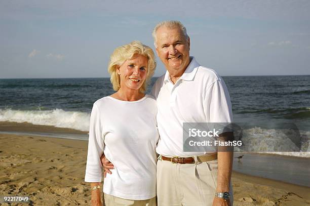 Photo libre de droit de Couple Senior Souriant Sur La Plage banque d'images et plus d'images libres de droit de 50ème anniversaire - 50ème anniversaire, 65-69 ans, Adulte