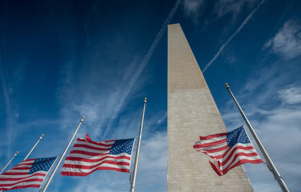 American Flags at Half Mast behind Chain Link Fencing.