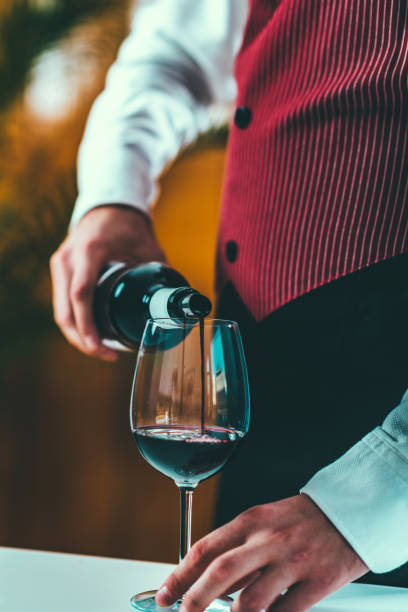 istock Midsection Of Man Pouring Wine In Wineglass On Table 922177166