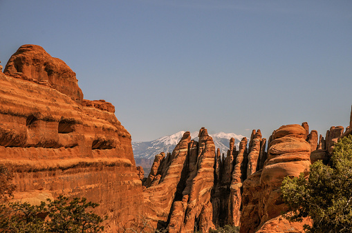 View of the distant La Sal mountains over vertical sandstone fins in Arches National Park, near Moab, Utah