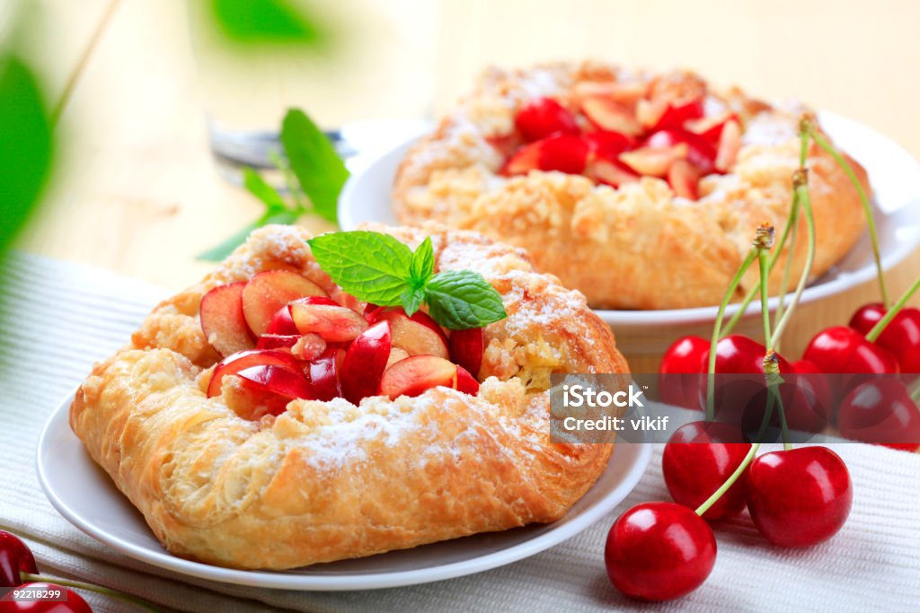Sweet pastry with cherries and mint leaf Sweet pastry topped with cherries Baked Stock Photo
