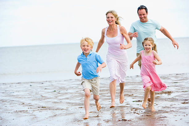 istock Family running on beach smiling 92220653