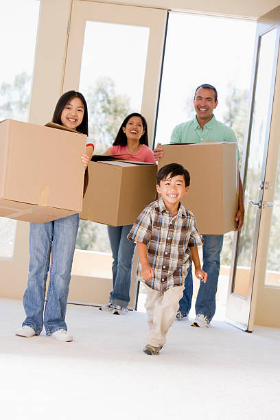 familia en movimiento en nueva casa sonriendo - moving house physical activity moving van box fotografías e imágenes de stock