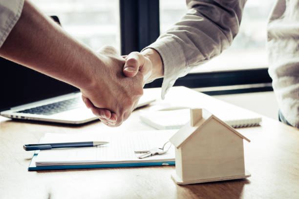 Successful agreement , estate,home buying contract concept, buyer shaking hand with bank empoyees after finishing signing contract in office stock photo