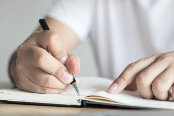 istock writing, knowledge and learning concept, hand of man recording information on notebook 922210360