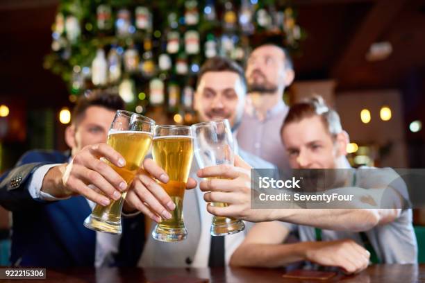 Clinking Beer Glasses Together Stock Photo - Download Image Now - Adult, Adults Only, Alcohol - Drink