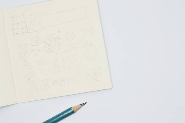 istock notebook with pencil sketches of science items on white background 922218134