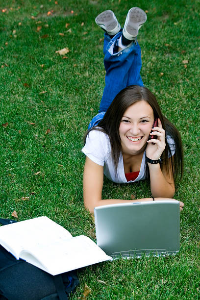 istock Cute Teenager Talking on the Phone while Studying 92221938