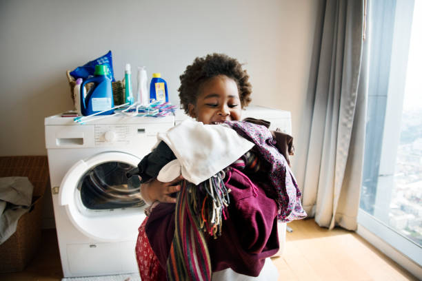 niño haciendo las tareas domésticas en el hogar - task fotografías e imágenes de stock