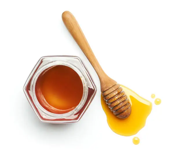 Honey dipper and jug over white background