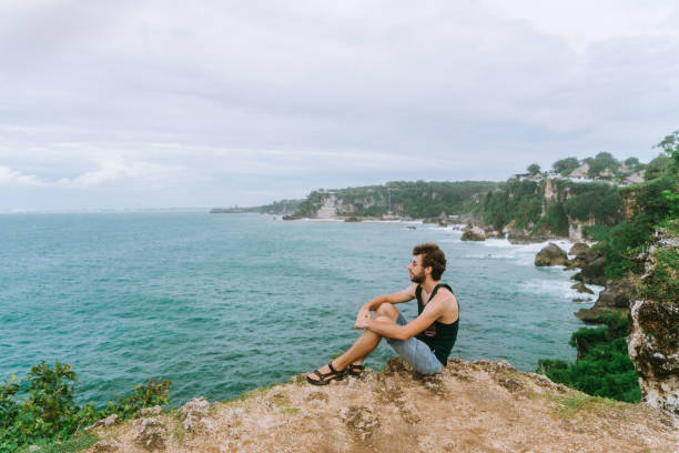 istock Man sitting  on cliff with view on ocean in Bali 922263946
