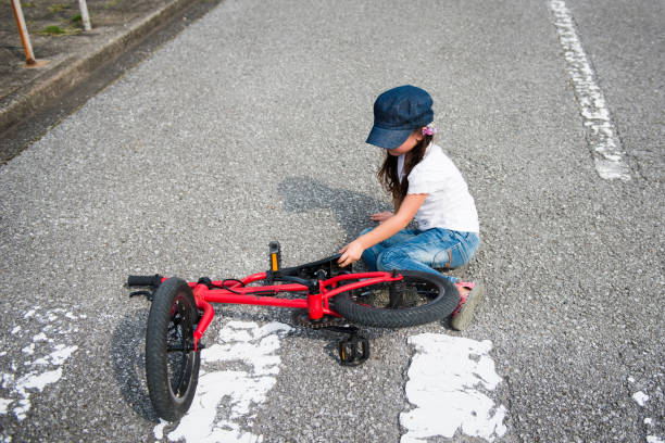 little girl who has fallen by bicycle - child bicycle cycling danger imagens e fotografias de stock