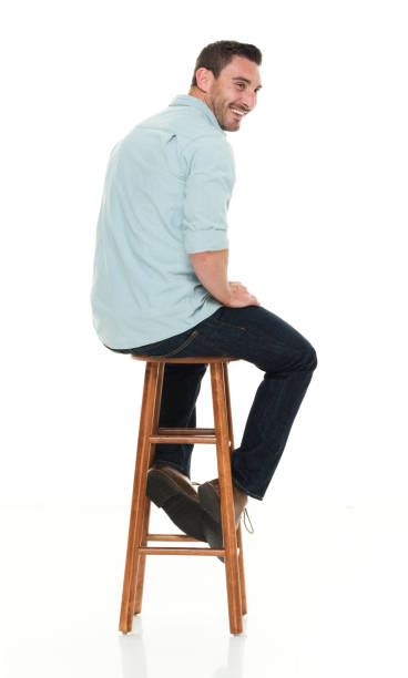 istock Handsome man seated on stool rear view 922289442