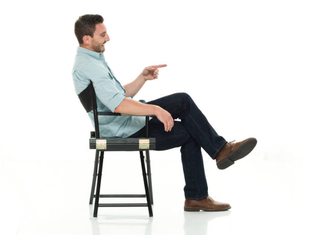 istock Charming man seated happy and on director's chair 922289512